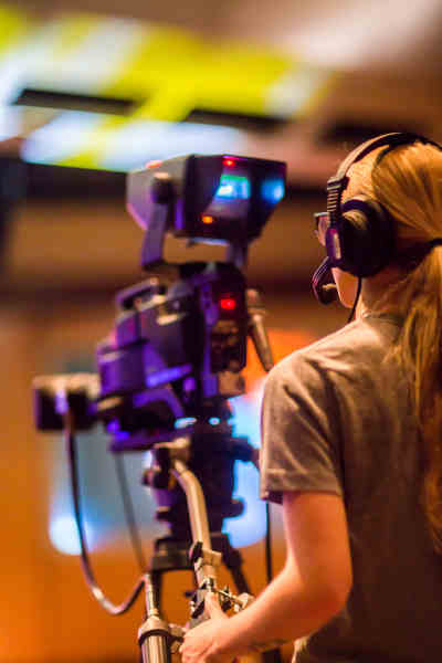 Image of person operating a video camera.